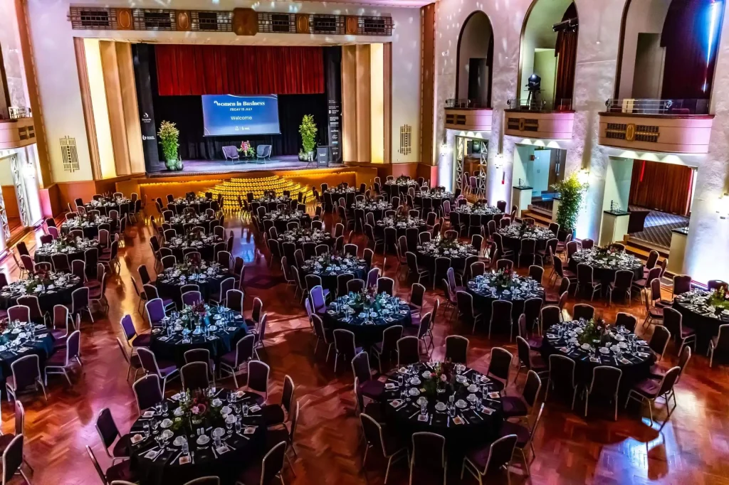 Grand corporate gala banquet setup with round tables and presentation stage inside The Great Hall at The Centre Ivanhoe.