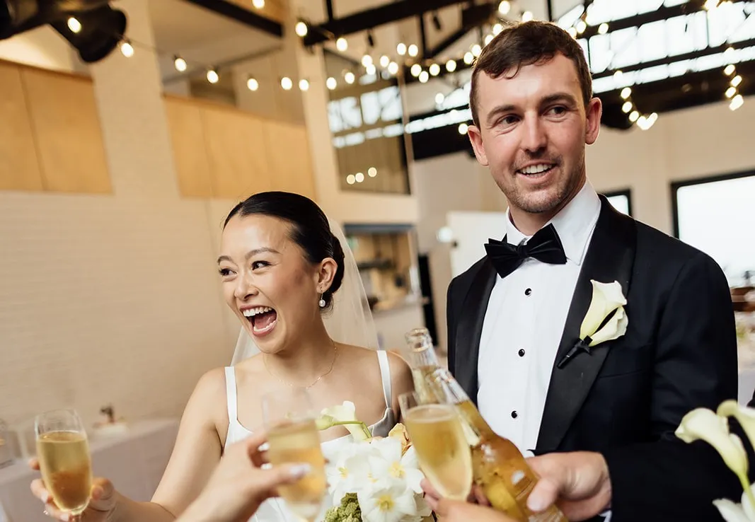 Bride and groom walking outside a heritage bluestone venue featuring bespoke wedding catering services by Peter Rowland.