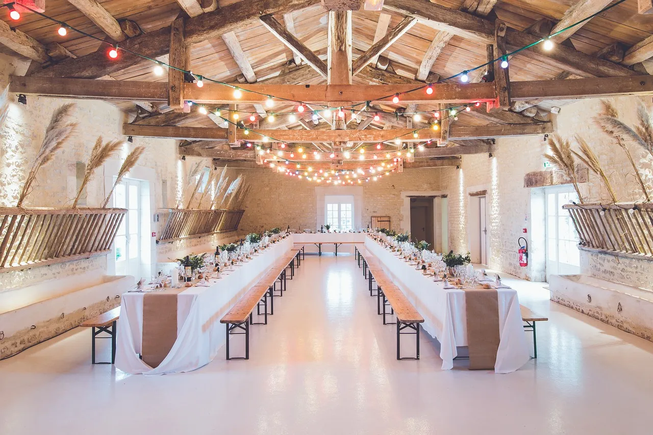 Long banquet tables set for a rustic wedding reception featuring luxury wedding catering services by Peter Rowland.