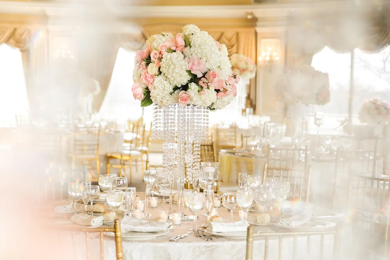 Elegant wedding reception table arrangement with crystal glassware and floral centerpieces by Peter Rowland catering.