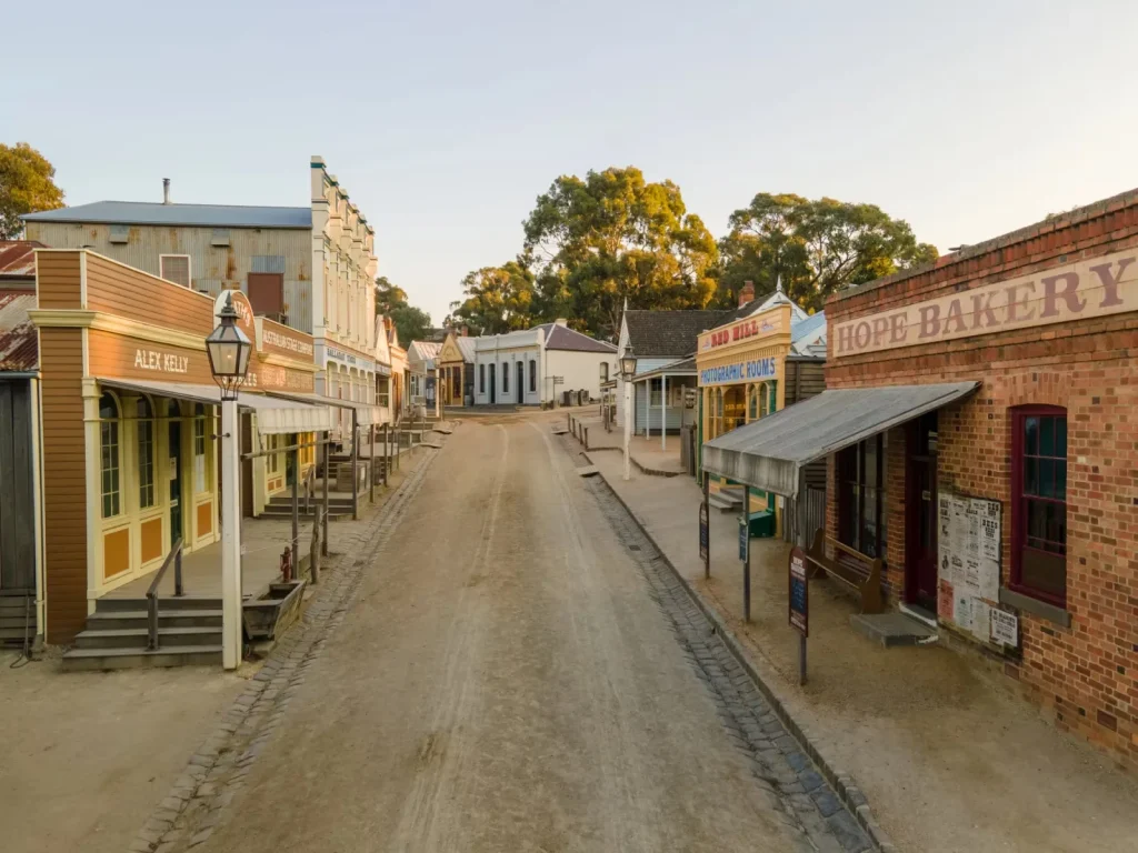 Historic 1850s gold rush township main street lined with authentic wooden heritage shopfronts at Sovereign Hill in Ballarat.