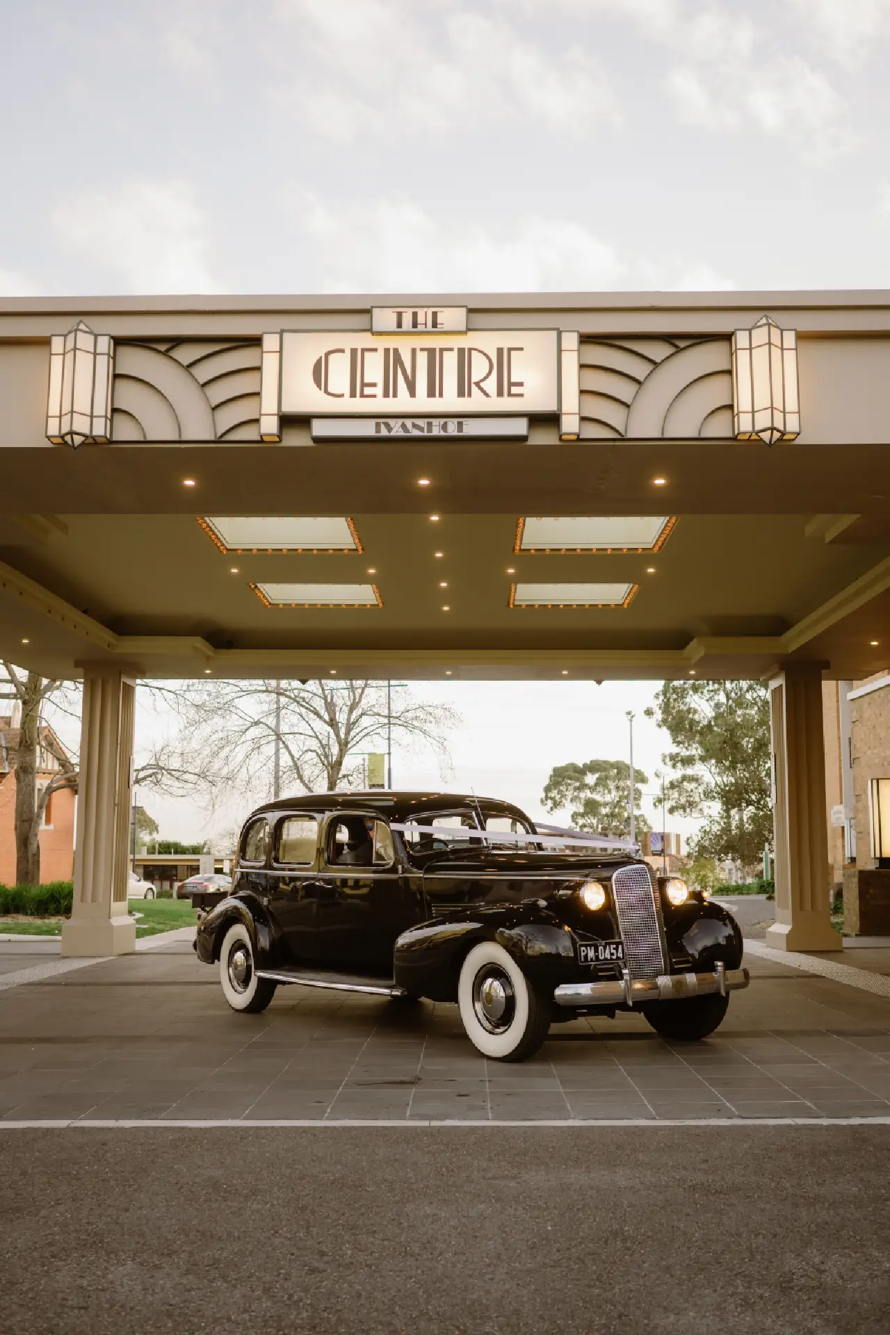Black vintage car parked at the main entrance porte-cochère of The Centre Ivanhoe.