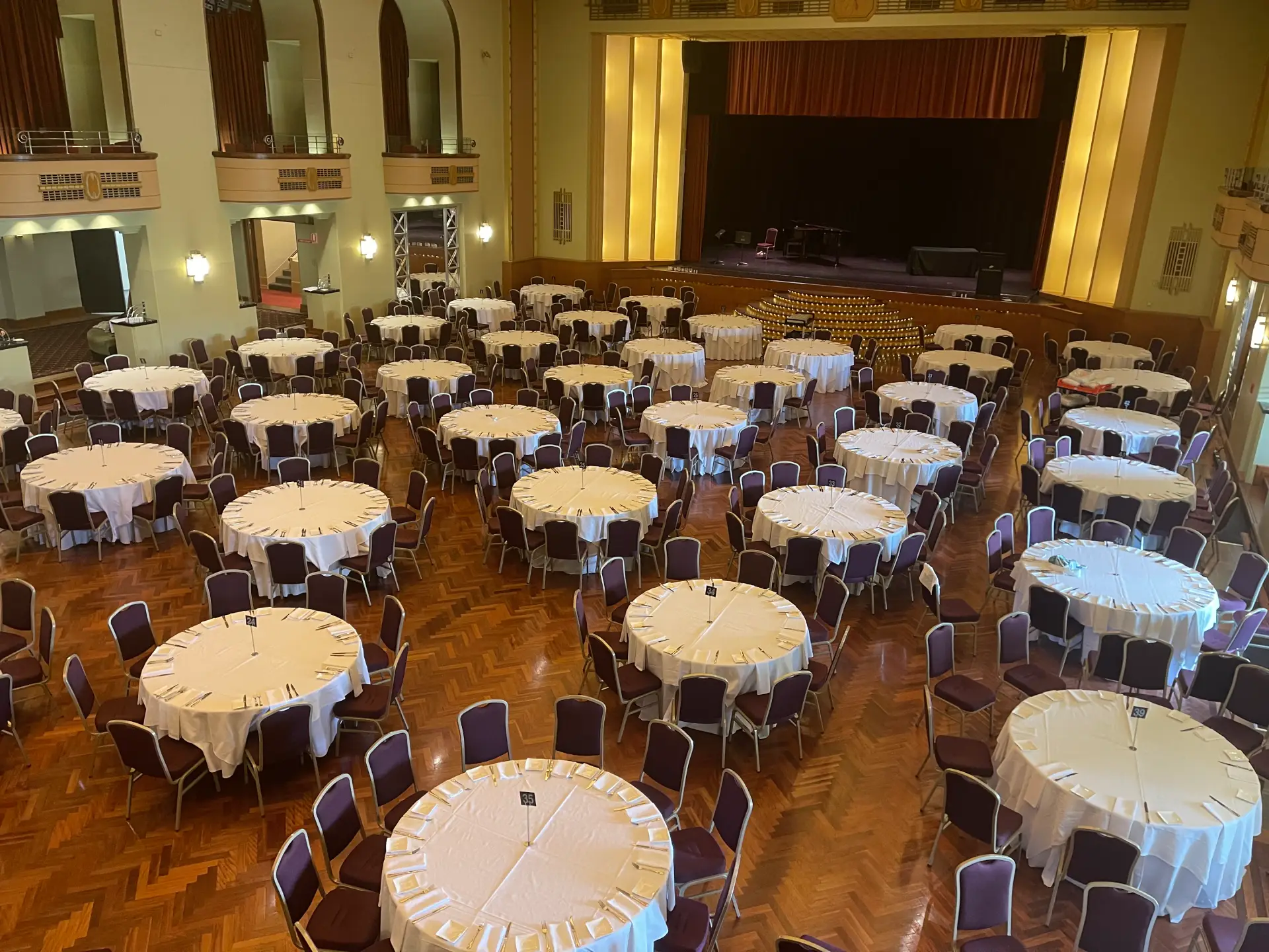 High-angle view of round banquet tables set up for a corporate dinner inside The Great Hall at The Centre Ivanhoe.