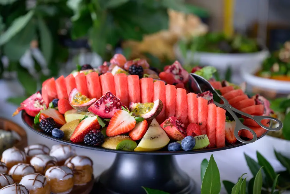 Freshly sliced seasonal fruit platter featuring watermelon, berries, and kiwi for corporate catering.