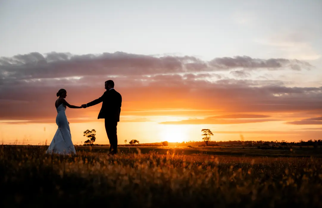 Silhouette of a bride and groom at sunset during a romantic destination wedding catered by Peter Rowland.
